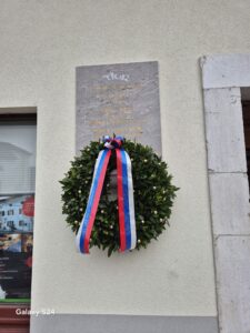 Venec in spominska plošča na pročelju Jeronove domačije v Kobaridu.